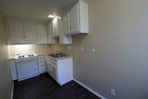a kitchen with white cabinets and a stove and a sink